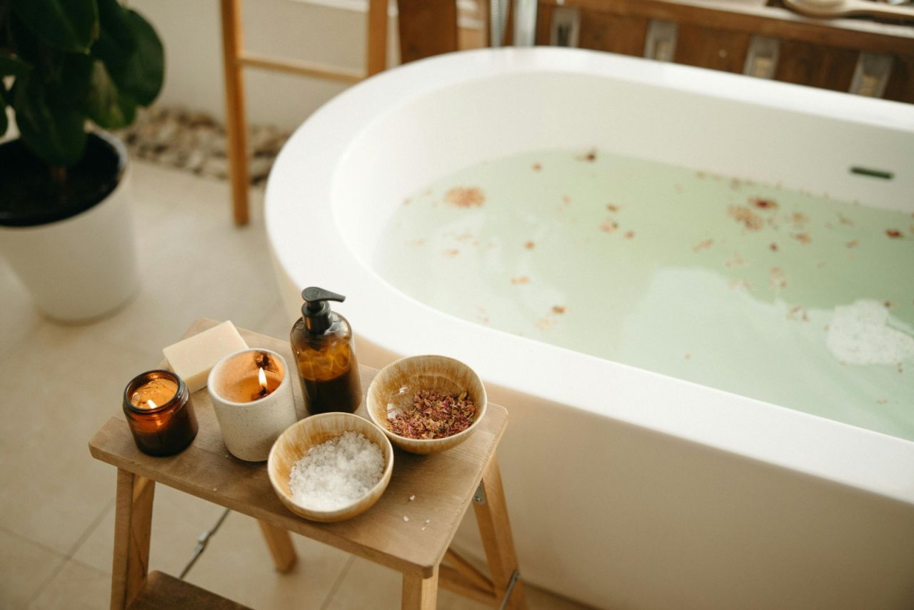 Badezimmer mit freistehender Badewanne und Holzhocker
