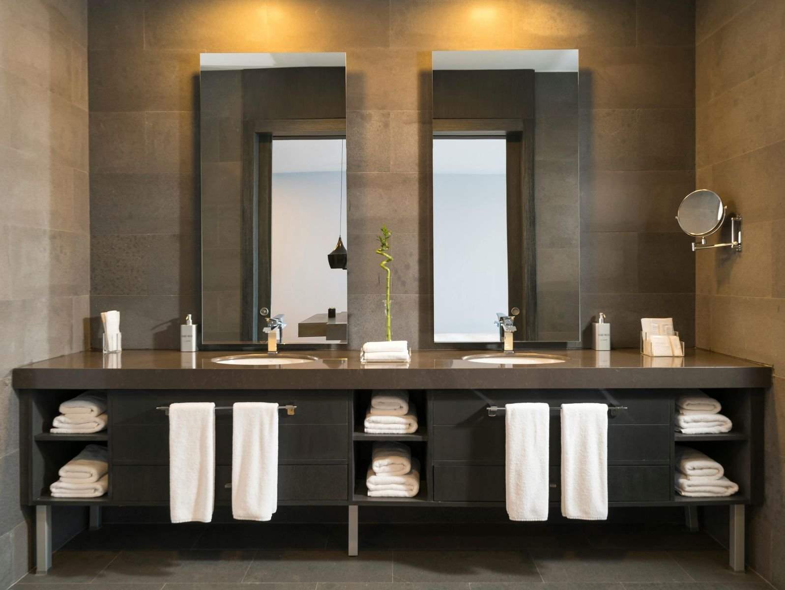 Badezimmer mit Doppelwaschtisch und zwei Spiegeln nebeneinander entlang der Wand
